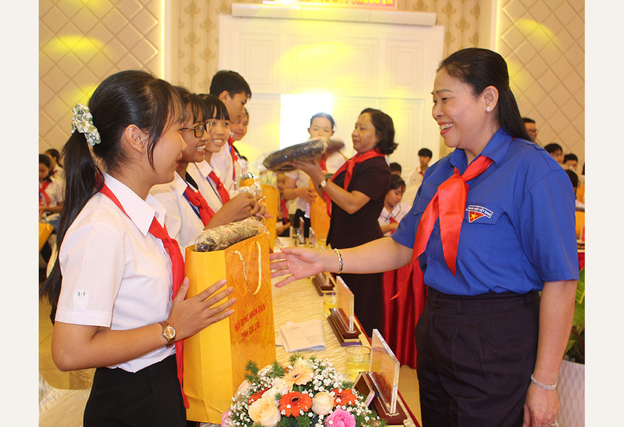 Phó Chủ tịch UBND tỉnh Huỳnh Nữ Thu Hà tặng quà cho các em thiếu nhi tham gia buổi đối thoại. Ảnh: P.L