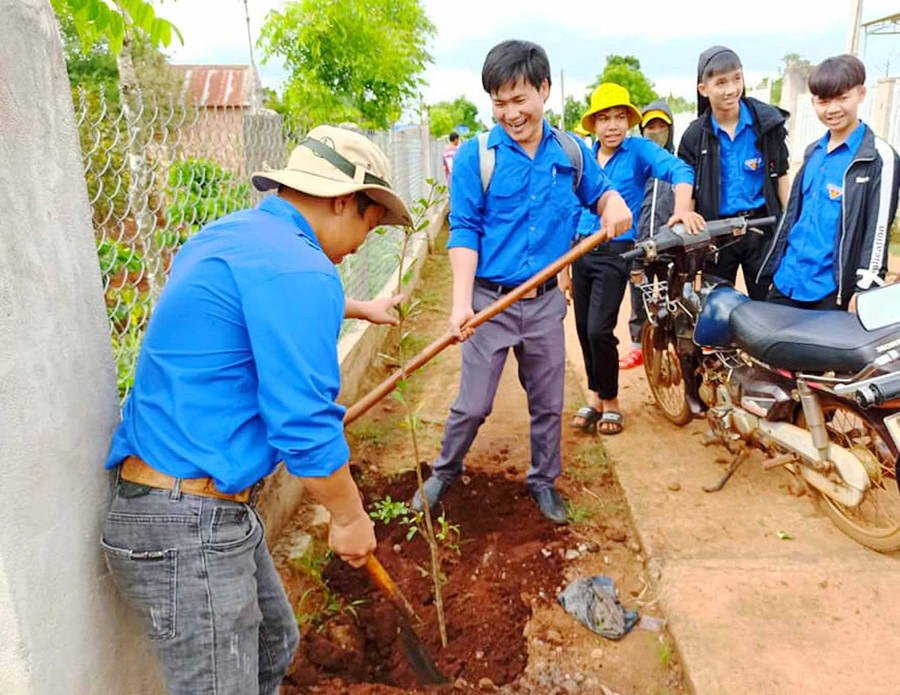 Đoàn viên, thanh niên trồng cây xanh dọc 2 bên đường làng Ia Mút. Ảnh: Hà Phương