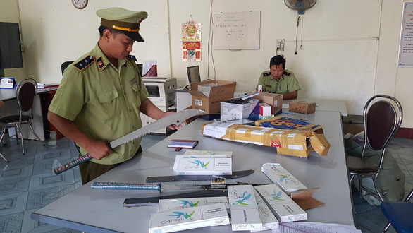  Đao, thuốc lá ngoại không rõ nguồn gốc trên xe thư báo - Ảnh: TRỌNG ĐÀI