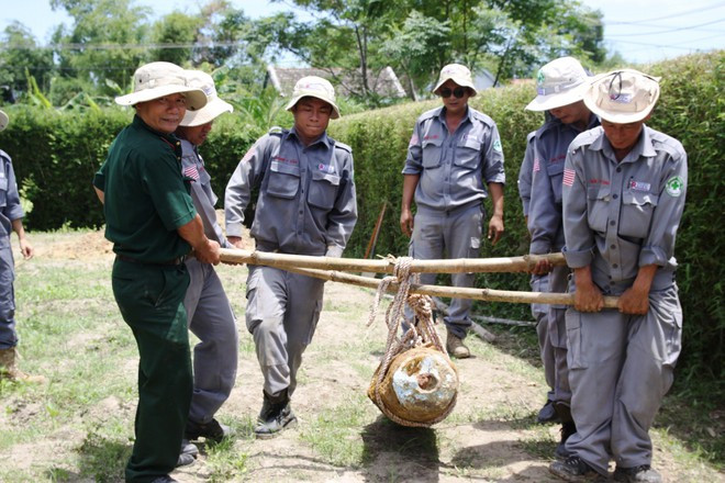 Những cán bộ của Renew/NPA bên cạnh một vỏ bom “khủng” vừa được hủy nổ ẢNH: NGUYỄN PHÚC