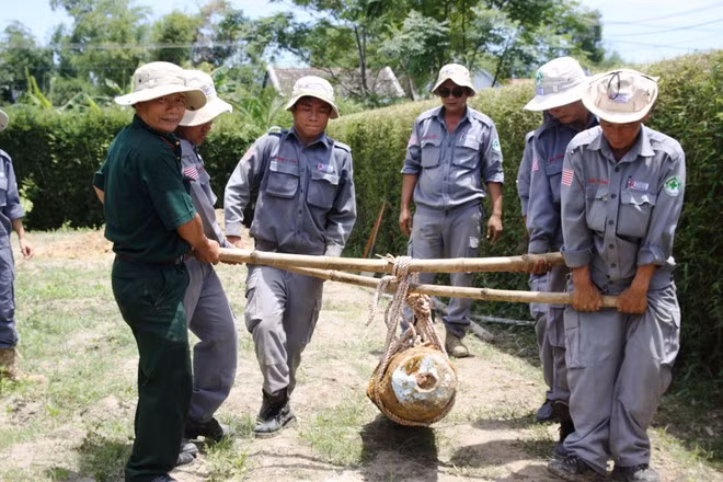 Những cán bộ của Renew/NPA bên cạnh một vỏ bom “khủng” vừa được hủy nổ ẢNH: NGUYỄN PHÚC