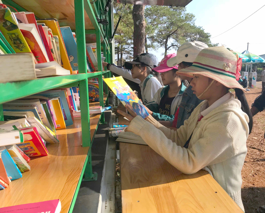 Các em học sinh đọc sách tại xe thư viện lưu động. Ảnh: Phương Linh Các em học sinh đọc sách tại xe thư viện lưu động. Ảnh: Phương Linh