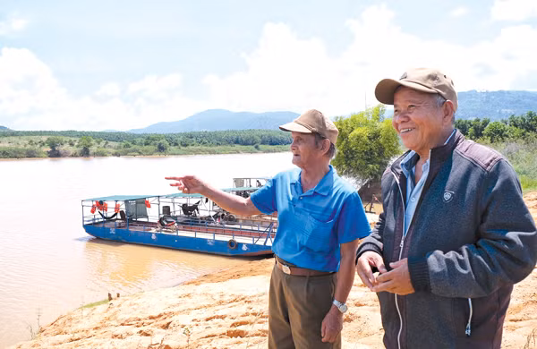 2 cựu chiến binh Rơ Châm Klớt (trái) và Rơ Lan Kai là những người lái đò trên dòng Pô Cô-một nhánh đường Trường Sơn huyền thoại trong kháng chiến chống Mỹ. Ảnh: MINH CHÂU 