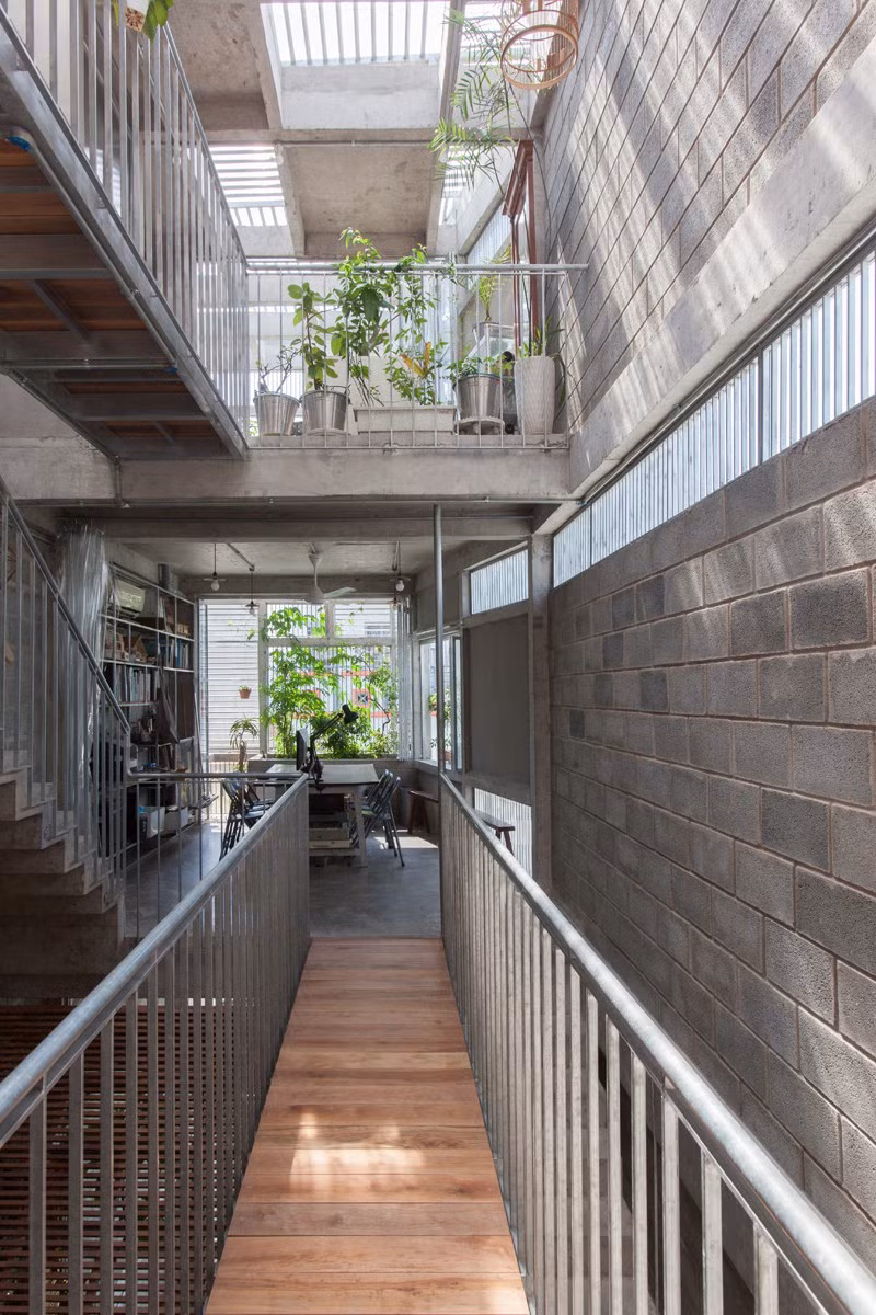 Cầu thang inox và gỗ để di chuyển lên tầng và giữa các không gian.