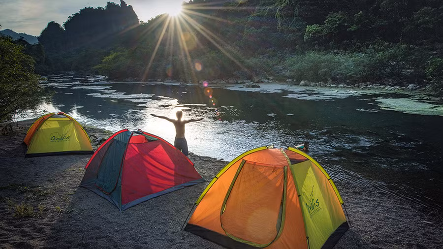 Mọi người cắm trại ngủ đêm bên dòng suối chảy ra từ lòng hang, bao nhiêu mệt mỏi dường như tan biến hết - Ảnh: N.V.H.