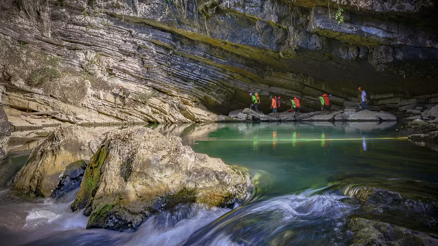 Trước khi vào hang Tiên phải đi qua hồ nước có màu xanh ngọc, dân địa phương gọi đây là hồ không đáy vì lòng hồ thông vào vách núi. Ảnh: N.V.H.