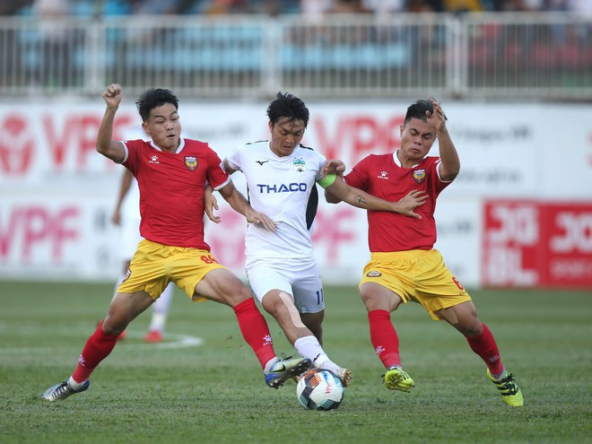 Tuấn Anh trong vòng vây kìm kẹp của 2 cầu thủ HLHT. Ảnh: MINH TRẦN