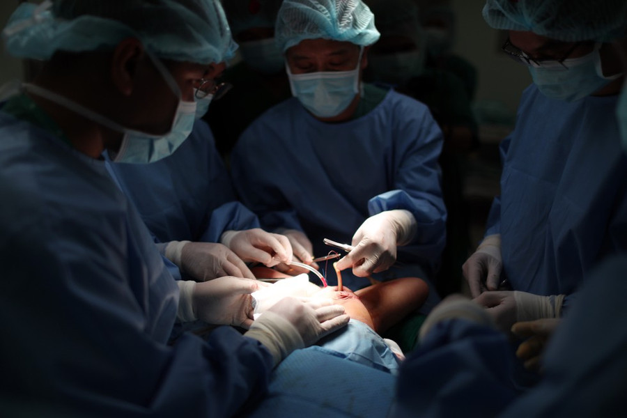 Các y bác sĩ tiến hành phẫu thuật chỉnh hình cho bé D.N, ca phẫu thuật tách rời cặp song sinh kéo dài hơn 12 giờ đồng hồ ẢNH: NGỌC DƯƠNG