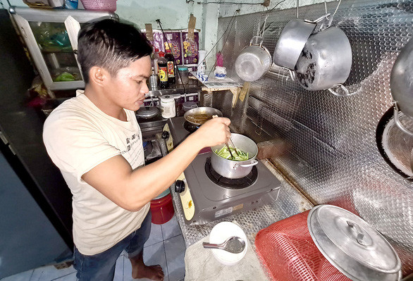 Lữ Văn Long chuẩn bị bữa cơm chiều cho vợ ở phòng trọ - Ảnh: NGỌC HIỂN