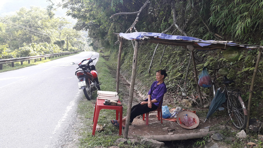 Bà Trầm với sạp hàng bán bánh củ chuối bên đường cho du khách. Ảnh: Văn Tiệp