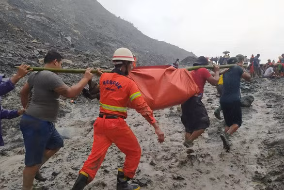 Người dân hỗ trợ đội cứu hộ đưa thi thể nạn nhân ra ngoài - Ảnh: REUTERS