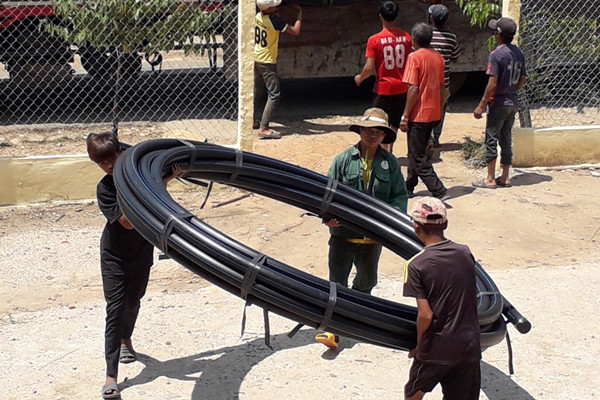 Vận chuyển ống nước xây dựng công trình nước tự chảy của làng. Ảnh: N.T