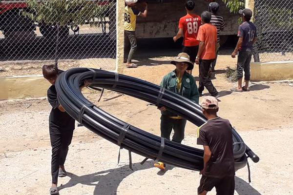 Vận chuyển ống nước xây dựng công trình nước tự chảy của làng. Ảnh: N.T