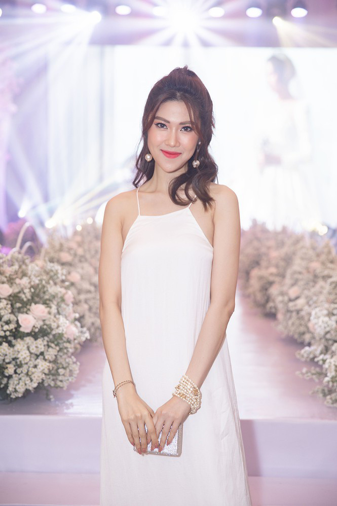 Siêu mẫu Thu Hằng lựa chọn kiểu váy yếm màu trắng trẻ trung khoe vai trần quyến rũ.