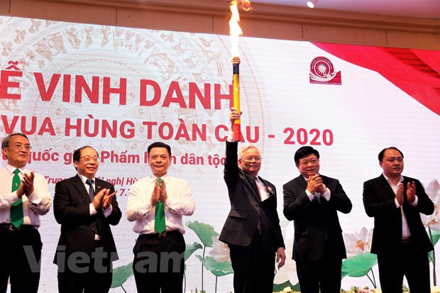 GS.TS Tạ Ngọc Tấn cùng các lãnh đạo, ban tổ chức chương trình giơ cao cây đuốc từ đền Hùng thiêng liêng. (Ảnh: Phương Linh/Vietnam+)