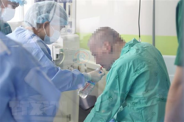 Bệnh nhân 91 đã ngồi dậy, ăn uống với sự hỗ trợ của nhân viên y tế. (Ảnh: TTXVN phát)