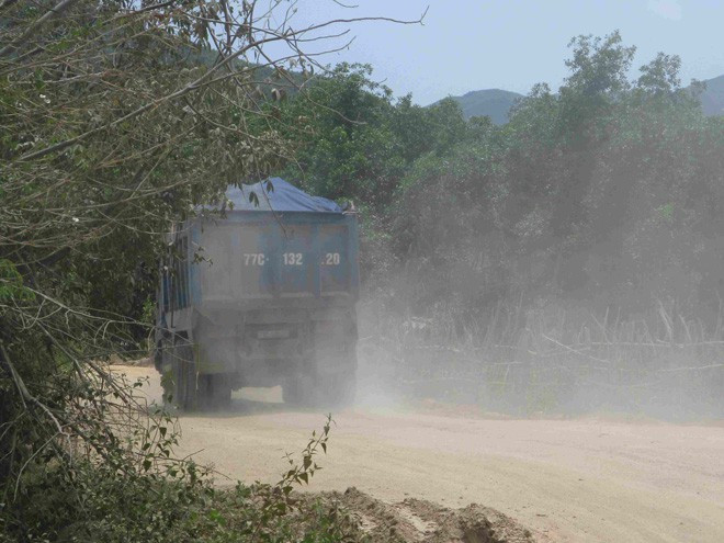 Vận chuyển đất khai thác từ núi Hòn Ách ra ngoài ẢNH: LÊ BÌNH