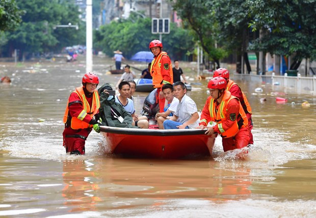  Lực lượng cứu hộ sơ tán người dân khỏi vùng ngập lụt. (Ảnh: THX/ TTXVN)