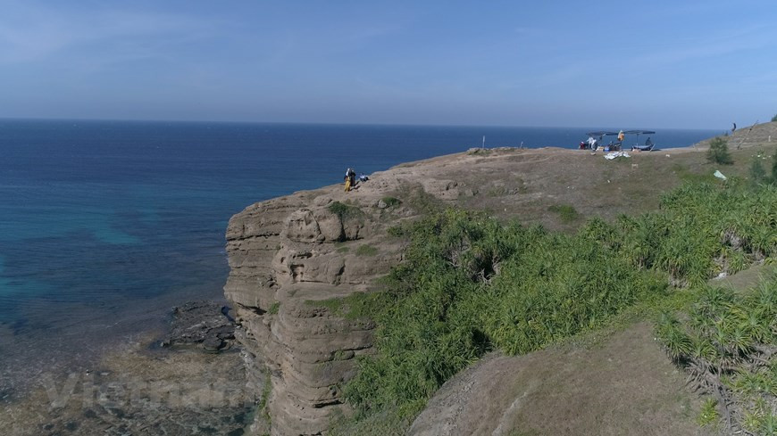 Chỉ mất chưa đầy 15 phút từ trung tâm huyện đi dọc theo con đường nhựa dưới chân núi Thới Lới về phía đông bắc, với hai bên đường là những vuông hành, tỏi xanh rì là đến bãi biển- nơi Hang Câu hiện hữu. Ảnh: Tùng Lâm/Vietnam+ Chỉ mất chưa đầy 15 phút từ trung tâm huyện đi dọc theo con đường nhựa dưới chân núi Thới Lới về phía đông bắc, với hai bên đường là những vuông hành, tỏi xanh rì là đến bãi biển- nơi Hang Câu hiện hữu. Ảnh: Tùng Lâm/Vietnam+