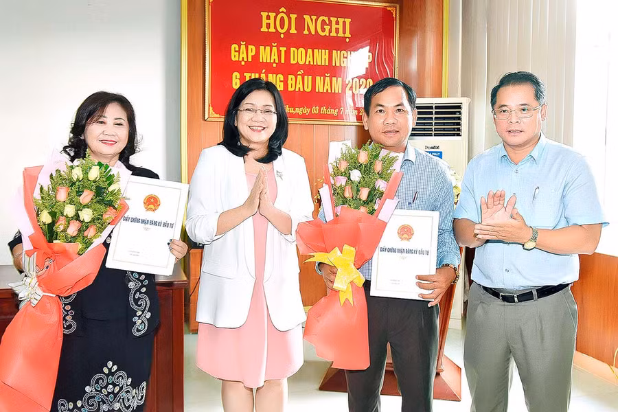 Giám đốc Sở KH-ĐT Hồ Phước Thành (bìa phải) trao giấy chứng nhận đăng ký đầu tư cho các doanh nghiệp. Ảnh: Đ.T