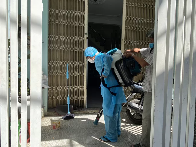 Cán bộ y tế phun hóa chất khử khuẩn tại nhà bên cạnh của bệnh nhân 418 sáng 26-7