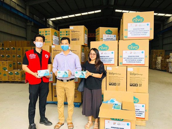 Đại diện VUSAC (phải), nhà sản xuất (giữa) và Hội Chữ thập đỏ Việt Nam chụp ảnh trước khi gửi chuyến khẩu trang viện trợ đầu tiên tới Mỹ cuối tháng 4-2020