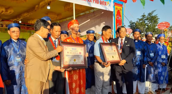 Đại diện Tổ chức Kỷ lục VN - Vietkings trao bằng xác lập 2 kỷ lục cho đại diện làng Phương Diên -Ảnh: B.N.L