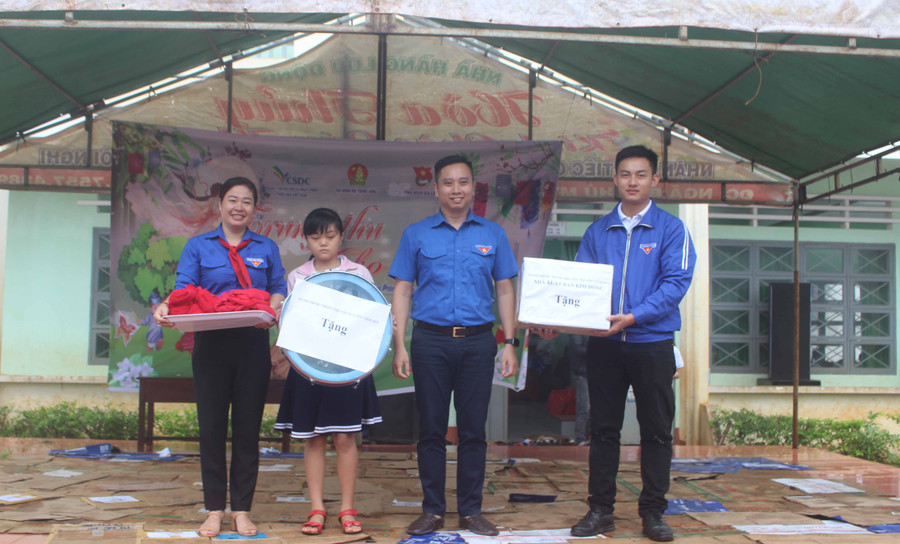 Anh Lê Anh Quân (thứ 2 từ phải qua)-Phó Trưởng ban Công tác thiếu nhi Trung ương Đoàn, trưởng đoàn công tác trao tặng các phần quà cho đại diện Trường Tiểu học Nguyễn Du. Ảnh: Phan Lài 