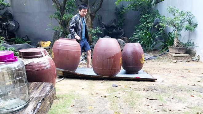 Một người trong hội quán chuẩn bị chum để hạ thổ rượu sâm Ngọc Linh - Ảnh: Quang Viên