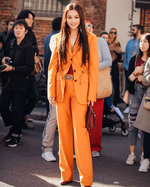  Dù đã gần kề U40 mà cô trông đẹp ngút ngàn với trang phục suit cam cá tính mix cùng giày và túi đỏ thanh lịch đến từ nhà mốt Salvatore Ferragamo