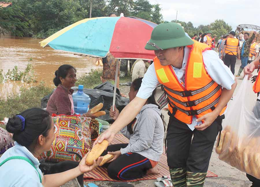  Cán bộ Công ty Hợp tác Kinh tế 385 cung cấp thực phẩm cho người dân Lào ở vùng lũ. Ảnh: L.Q