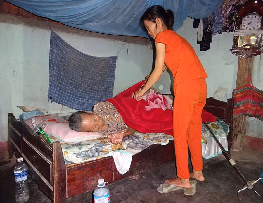  Chị Mai Thị Liêm chăm sóc mẹ già. Ảnh: H.P