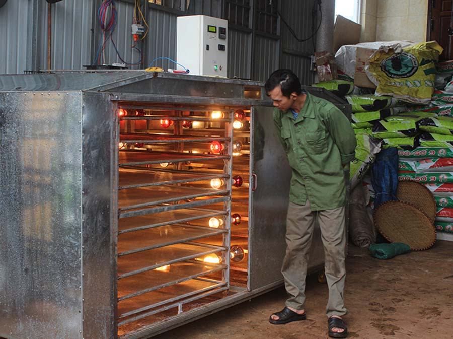  Ông Trần Quang Sơn (thôn 5, xã Nam Yang, huyện Đak Đoa) bên máy sấy hồng ngoại chế biến các sản phẩm hồ tiêu. Ảnh: N.D