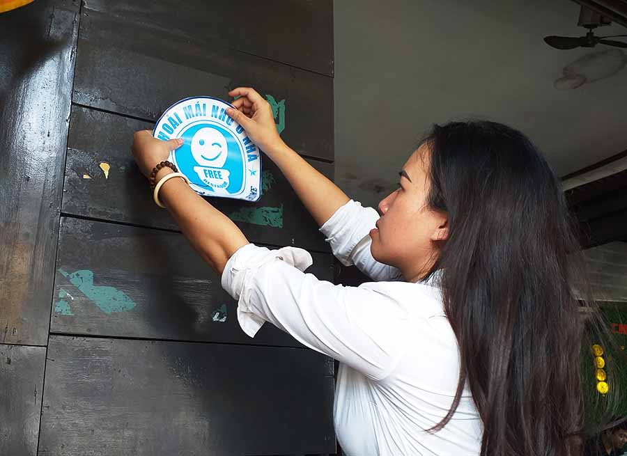  Cán bộ phường Tây Sơn (TP. Pleiku) dán logo nhận diện nhà vệ sinh miễn phí tại các cơ sở kinh doanh đăng ký tham gia phong trào. Ảnh: H.T