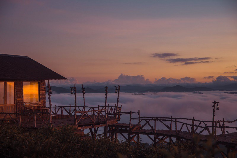 Căn chòi trên cầu gỗ ấm áp hơn hẳn trong làn mây bồng bềnh phía ngoài.