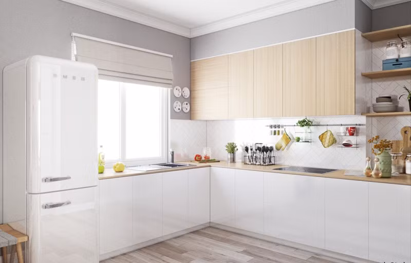 Tủ bếp chữ L tận dụng tối đa diện tích. Chiếc tủ lạnh màu trắng gần như trong suốt.