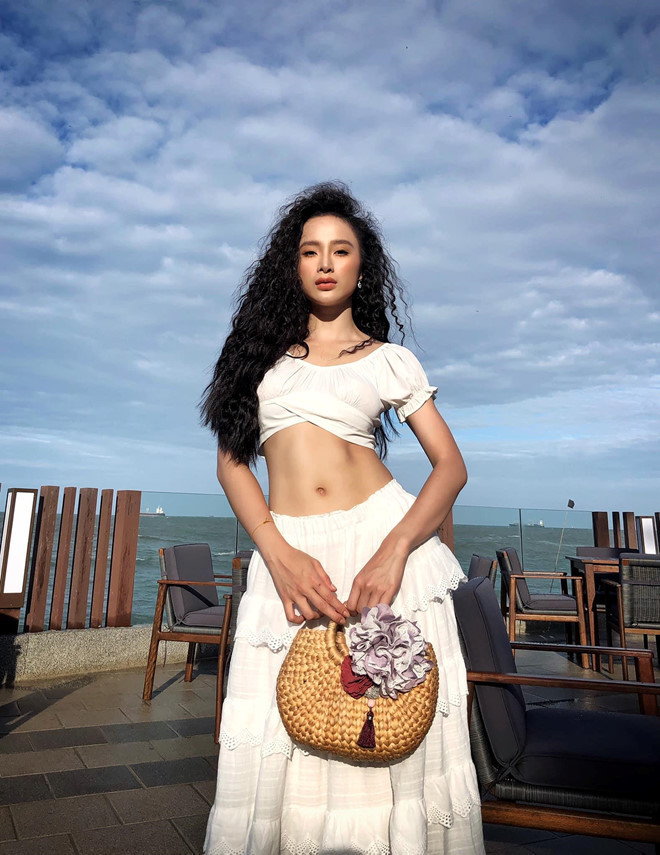  Áo croptop trắng và chân váy dài màu trắng không những mang đến sự xinh đẹp cho Phương Trinh mà còn giúp cô khoe được lợi thế hình thể mà ở đây chính là vòng eo thon và cơ bụng săn chắc khó ai sánh bằng này