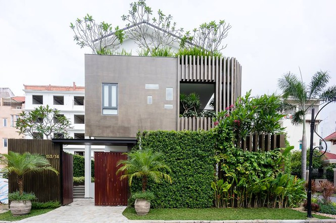  Đập vào mắt người đi đường là mặt tiền xanh mướt với mảng tường phủ kín cây xanh cùng lối vào bằng gỗ mộc mạc xinh xắn của biệt thự đẹp tại quận 7, TP. HCM.