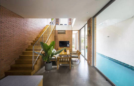 Ngoài 12 bậc thang bồn cây được lồng ghép xen kẽ và chạy liên tiếp từ tầng trệt lên đến sân thượng, ngôi nhà còn gây ấn tượng và thỏa mãn niềm đam mê bơi lội của chủ nhà bằng một bể bơi dài 11m ở ngay bên cạnh phòng khách. hình ảnh ngôi nhà tại đây.