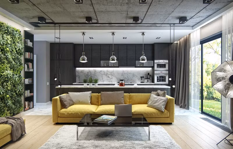 Căn hộ có diện tích khá nhỏ vậy nên nhà bếp đặt liền kề với phòng khách. Trong đó khu vực tiếp khách được làm nổi bật với ghế sofa màu vàng và bức tường bằng cây.