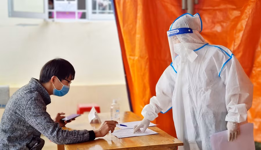 Nhân viên y tế phường Ia Kring (TP. Pleiku) hướng dẫn người dân khai báo y tế. Ảnh: Bá Bính