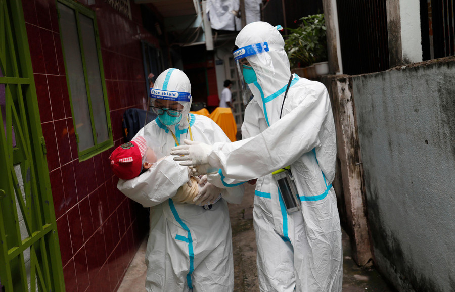 Nữ sinh viên tình nguyện Trường ĐH Y khoa Phạm Ngọc Thạch đưa một em bé bị nhiễm Covid-19 đến bệnh viện cấp cứu