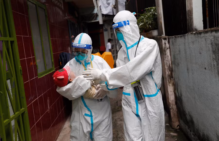 Nữ sinh viên tình nguyện Trường ĐH Y khoa Phạm Ngọc Thạch đưa một em bé bị nhiễm Covid-19 đến bệnh viện cấp cứu