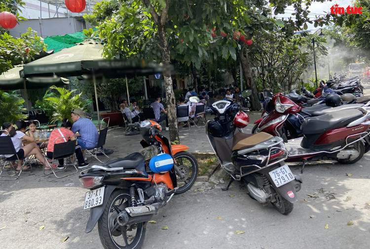 Một quán cà phê trên địa bàn quận Bình Tân chật kín khách và xe máy dựng phía trước dù chính quyền TP Hồ Chí Minh vẫn chưa cho phép các quán ăn, uống được phục vụ tại chỗ. Ảnh: Mạnh Linh/Báo Tin tức