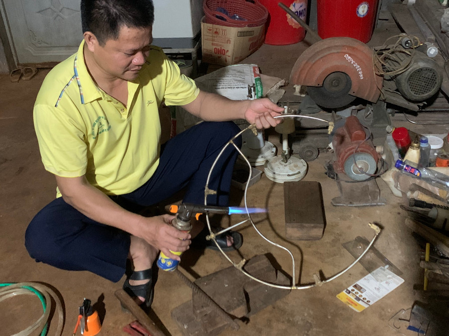 Anh Bổng làm vòng phun thuốc trị bệnh Botryo trên cây cao su. Ảnh: Thiên Di