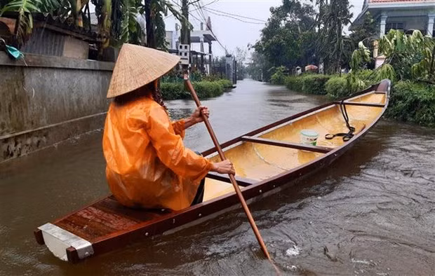 Mưa lớn trên diện rộng khiến nhiều tuyến đường bị ngập tại huyện Quảng Điền (Thừa Thiên-Huế), người dân phải dùng thuyền để di chuyển. (Ảnh: Tường Vi/TTXVN)