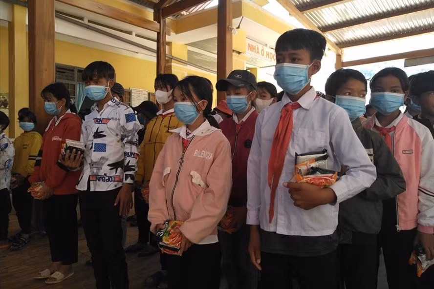 Các em học sinh bán trú nhận mì tôm trong ngày cuối tuần. Ảnh: T.T