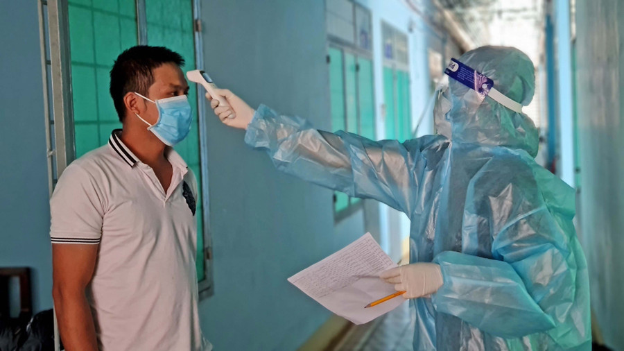 Nhân viên y tế kiểm tra thân nhiệt công dân thực hiện cách ly tại khu cách ly tập trung Trường Chính trị tỉnh Gia Lai, phường IaKring, TP. Pleiku. Ảnh: Bá Bính