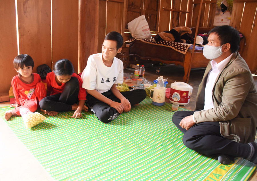 Ông Đinh Nao (bìa phải)-Bí thư Đảng ủy xã Đak Rong (huyện Kbang) đến động viên gia đình anh Đinh Văn Dũng (làng Kon Lanh) vượt qua khó khăn trước mắt sau khi vợ tự tử. Ảnh: Phương Duyên