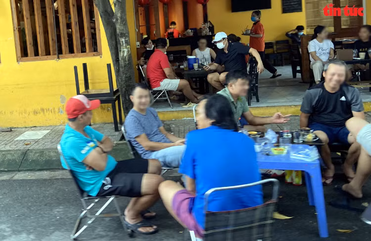  Vào ngày cuối tuần, các quán cà phê ở phường Tân Thành (quận Tân Phú, TP Hồ Chí Minh) chật kín khách từ trong ra ngoài, nói chuyện vô tư và không đeo khẩu trang dù chính quyền TP Hồ Chí Minh vẫn chưa cho phép hàng quán phục vụ tại chỗ. Ảnh: Mạnh Linh/Báo Tin tức